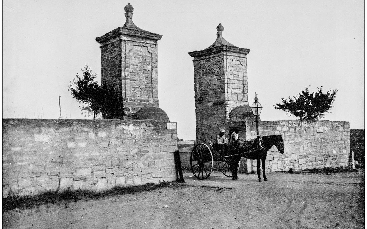 A historic photograph of a horse and cart passing through the Old City Gates in St. Augustine